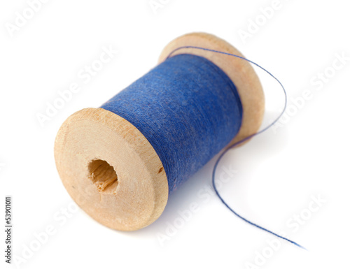 Wooden spool of blue thread photo