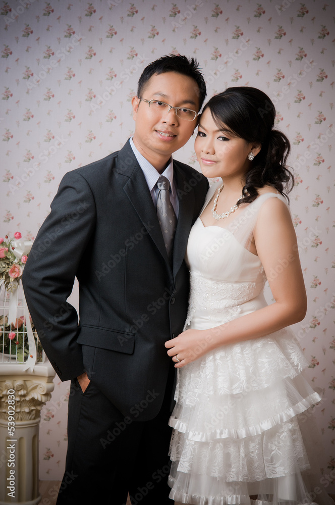 Bride and Groom posing in wedding dress at studio, smiling Bride and Groom posing in wedding dress at studio, smiling