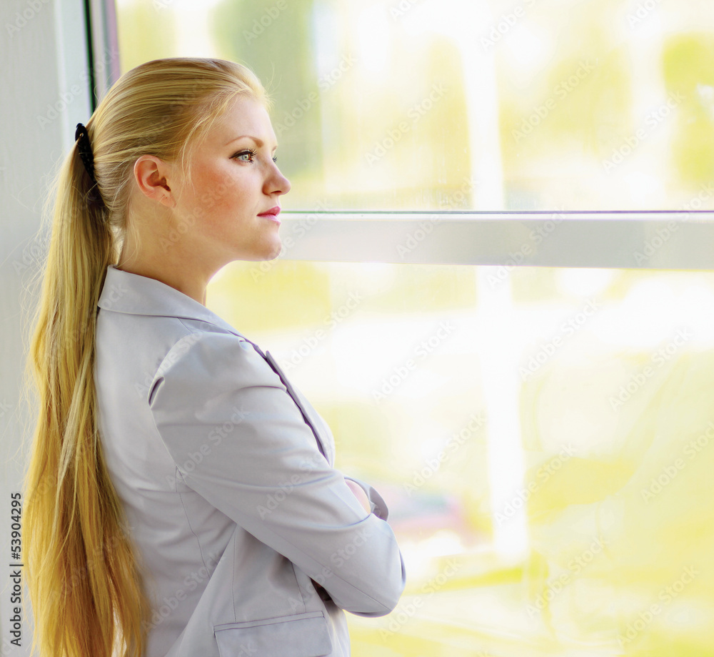 business woman in modern building , standing near windows business woman in modern building , standing near windows