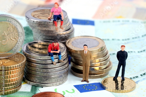 Männchen sitzen auf Euomünzen, Finanzen, Geld photo