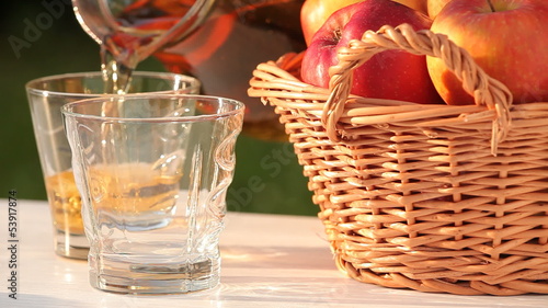 Basket with apples and pouring apple juice.