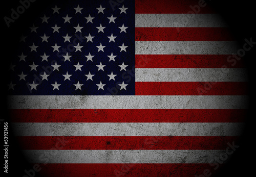 Dark grunge textured US Flag with spot light.