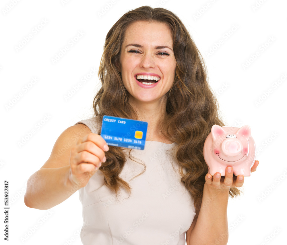 Happy young woman showing credit card and piggy bank Happy young woman showing credit card and piggy bank