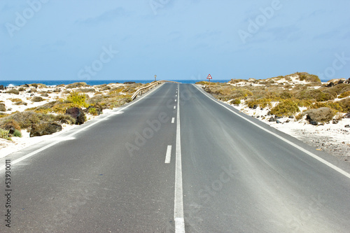Empty road between mountains leading to the sea, Canary islands