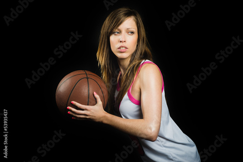 Young blonde in a defense position with a basketball