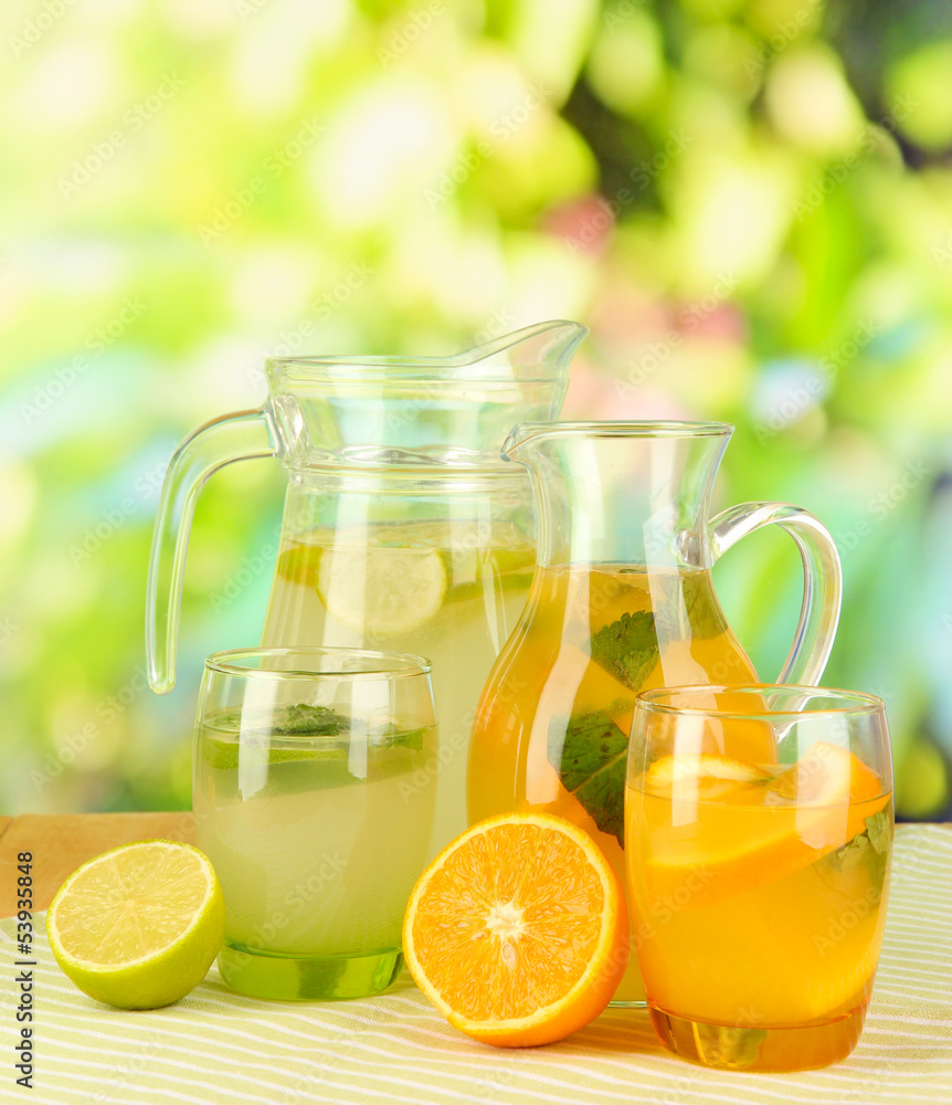 Orange and lemon lemonade in pitchers and glasses Orange and lemon lemonade in pitchers and glasses