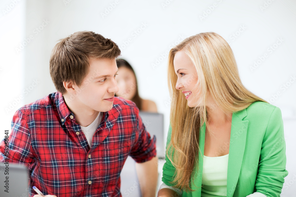smiling students looking at each other at school smiling students looking at each other at school