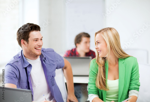 smiling students looking at each other at school
