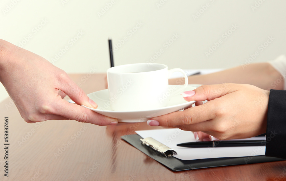 Close up of businesswoman hands with cup of coffee during Close up of businesswoman hands with cup of coffee during