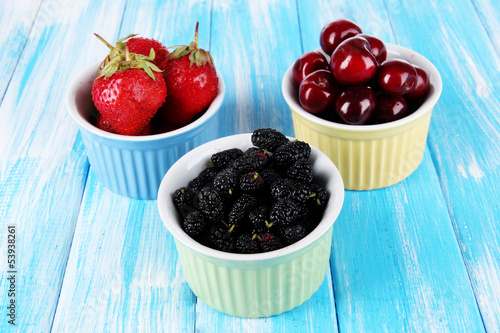Ripe mulberries with cherry and strawberries in bowls
