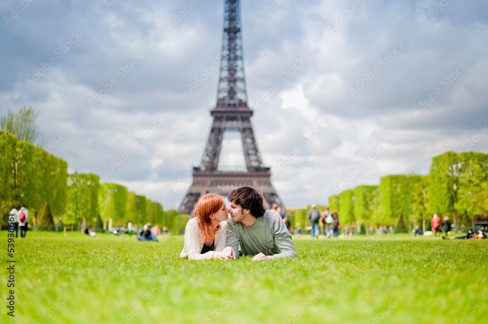 Obraz premium Loving couple kissing near the Eiffel Tower in Paris