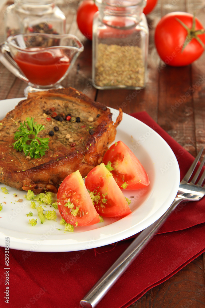 Piece of fried meat on plate on wooden table close-up