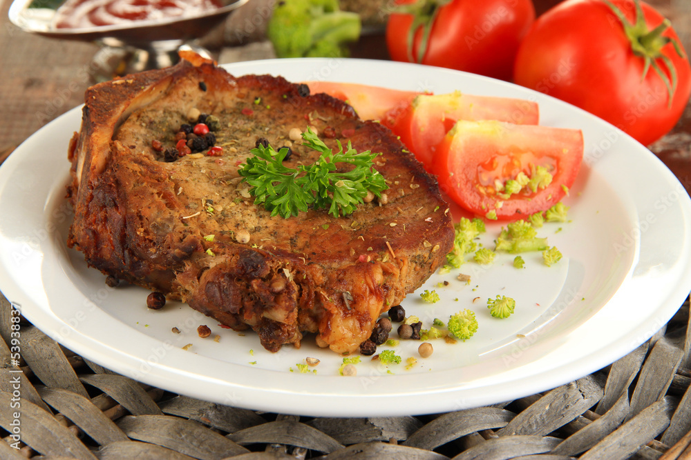 Piece of fried meat on plate on wooden table close-up