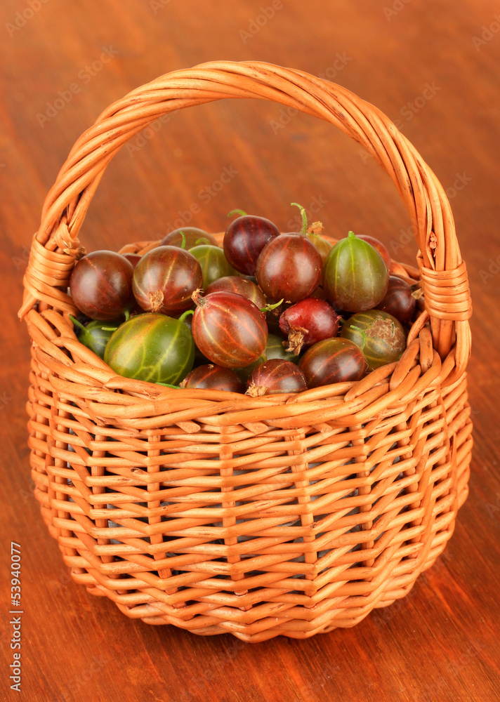 Fresh gooseberries in wicker basket on table close-up Fresh gooseberries in wicker basket on table close-up