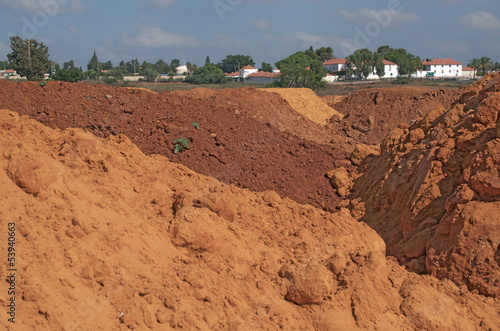 Quadro su tela Colorful red soil dunes in Israel with kibbutz houses and trees