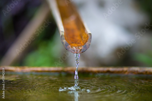 Bamboo fountain with water in a temple © piccaya