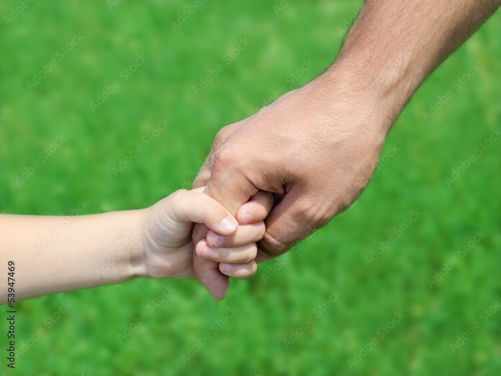 Child holds the hand of the father Child holds the hand of the father