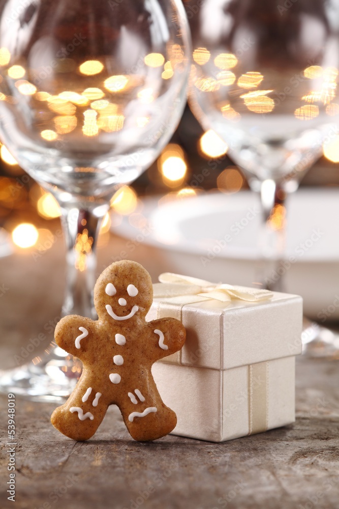 Gingerbread man and gift box on Christmas table.