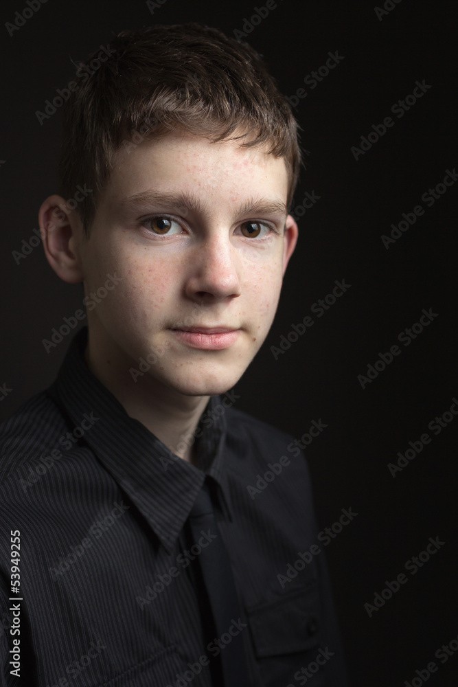 Portrait of a teenage boy against dark background Portrait of a teenage boy against dark background