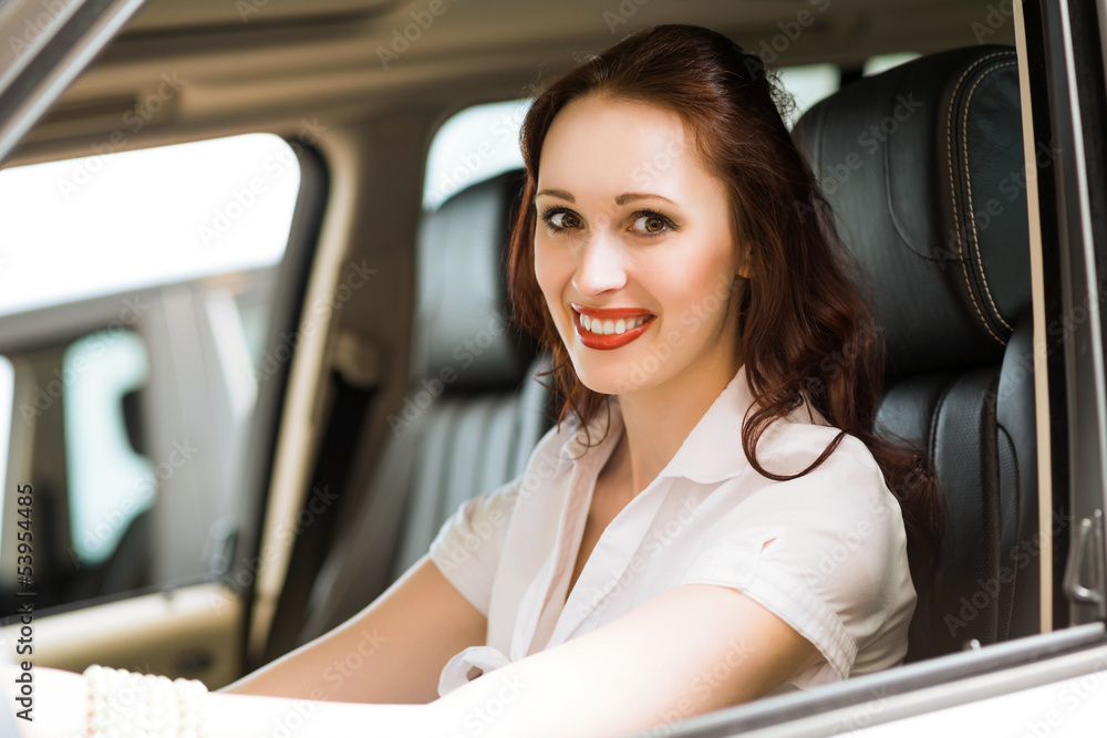 young woman in the new car in the showroom young woman in the new car in the showroom