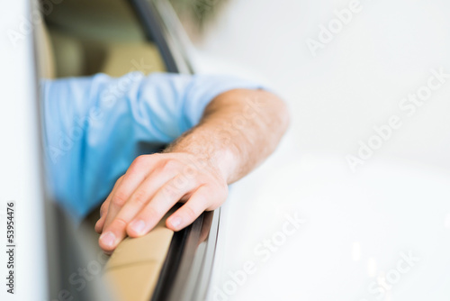 man's hand is on the door of the car