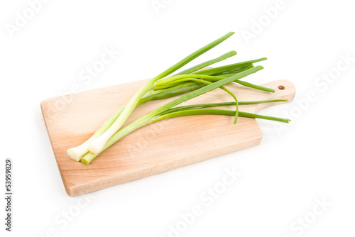 Spring onion on cutting board isolated on white