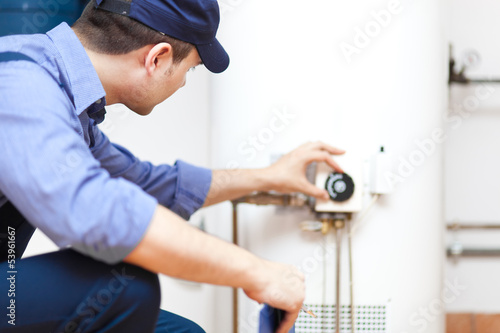 Plumber repairing an hot-water heater photo