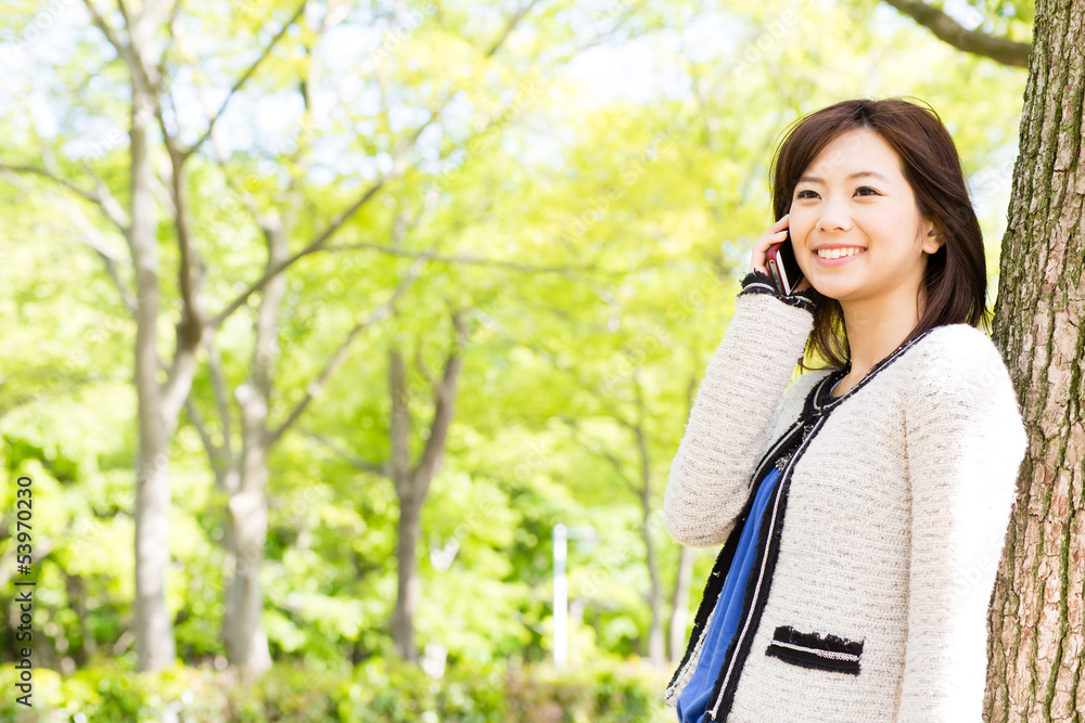 young asian woman talking in the park young asian woman talking in the park