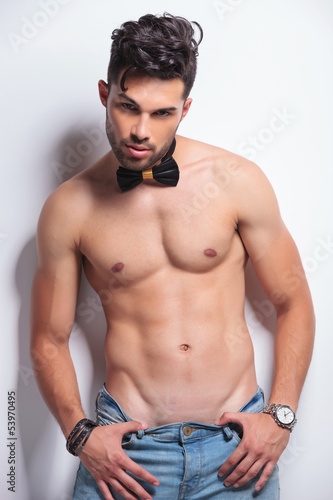 topless young man pulls dow his pants