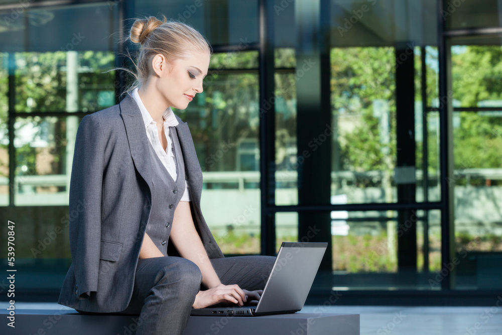 Young businesswoman working on laptop outdoors Young businesswoman working on laptop outdoors