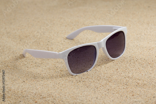 white trendy sunglasses on beach sand