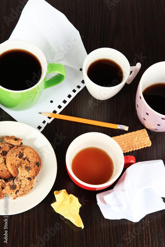 Cups of coffee and cookies on plate on dark background