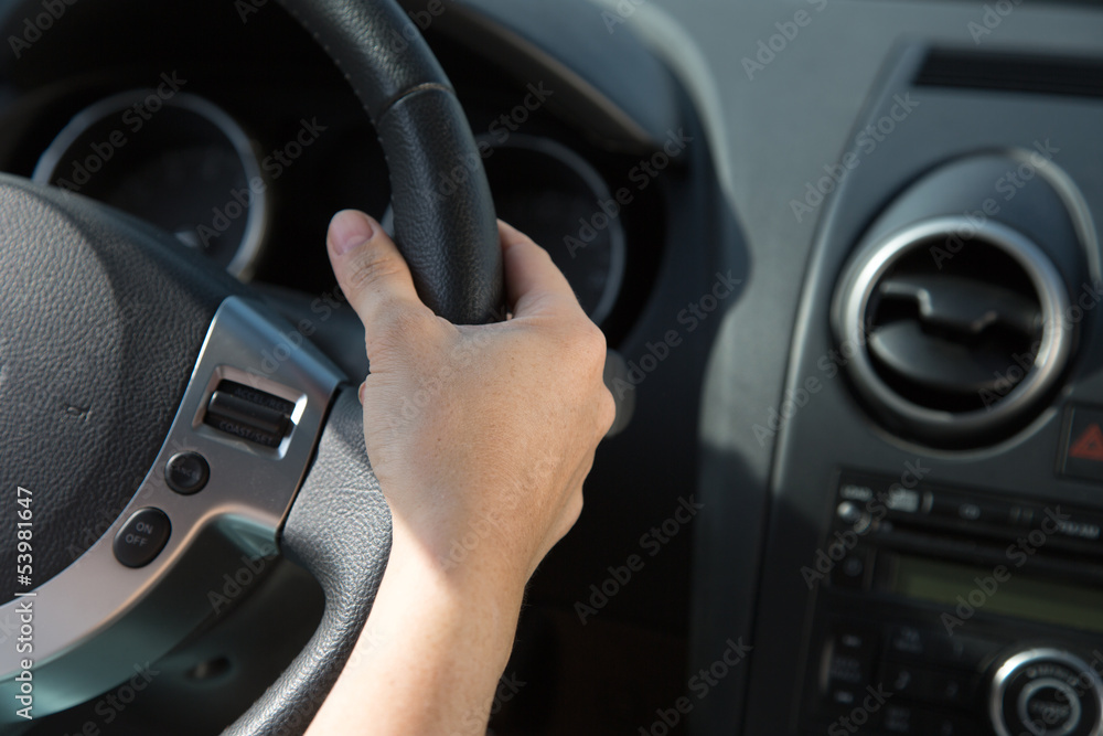 Hand am Lenkrad eines Autos