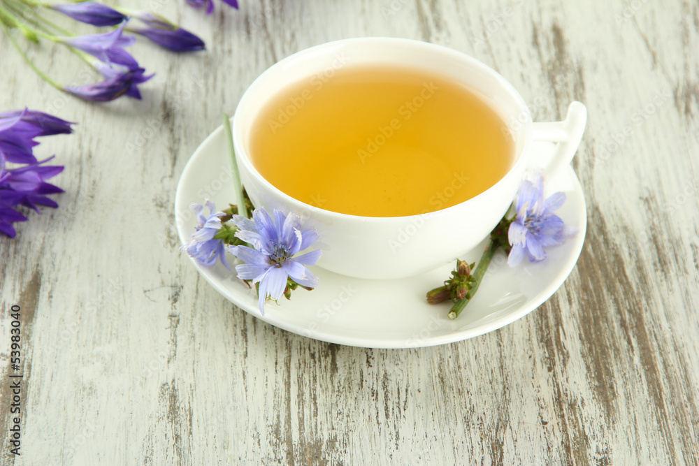 Cup of tea with chicory, on wooden background Cup of tea with chicory, on wooden background