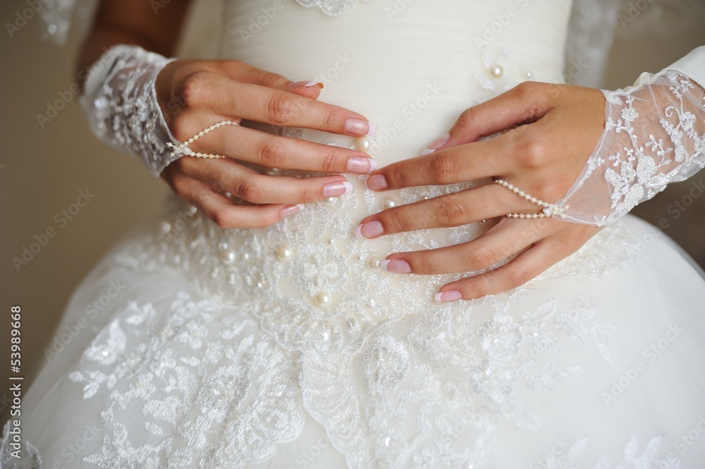 Bride hands on wedding dress