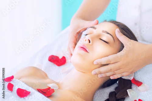Young beautiful woman receiving head massage at spa