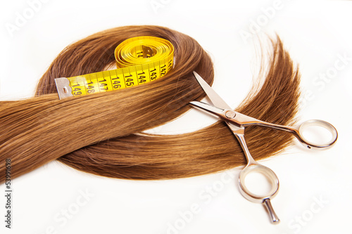 hairdresser scissors on hair with measuring tape