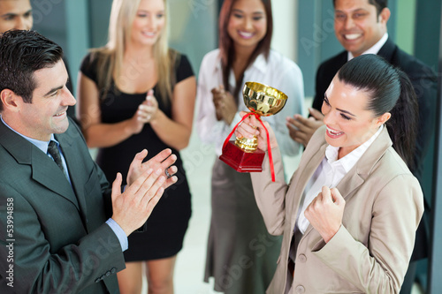 фотографія cheerful female corporate worker receiving a trophy