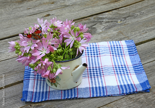 Rustic still life with a bouquet of pink mallow and butterfly photo