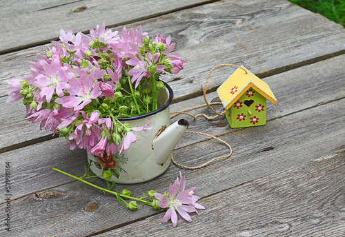 Summer still life with a bouquet of pink mallow and birdhouses photo