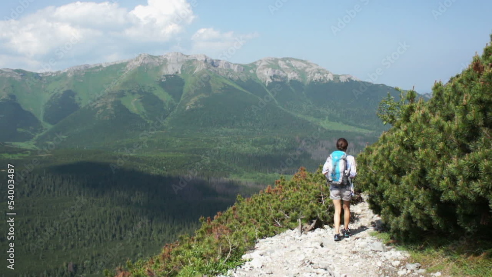Young woman hiking in the mountains, rear view Young woman hiking in the mountains, rear view