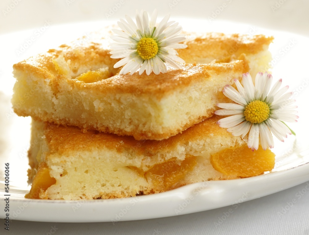 Fruitcake with peach and daisy flowers on white plate Fruitcake with peach and daisy flowers on white plate