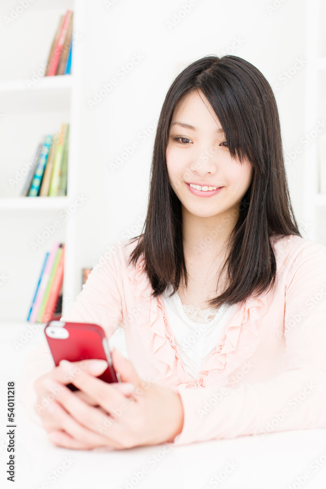 attractive asian woman using smart phone in the room attractive asian woman using smart phone in the room