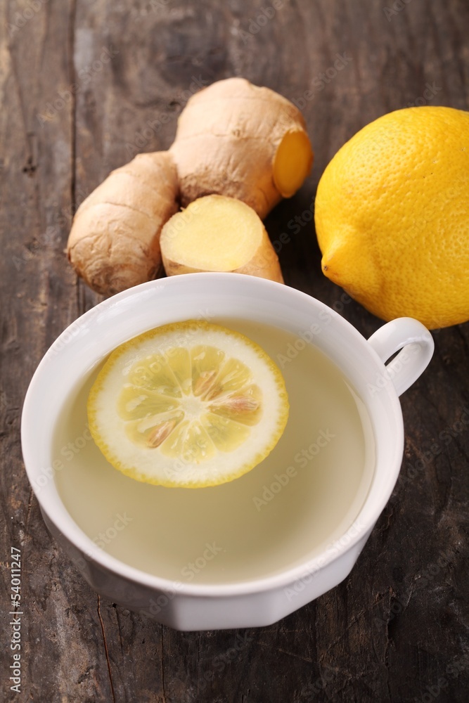 Cup of ginger tea and fresh ingredients - ginger and lemon. Cup of ginger tea and fresh ingredients - ginger and lemon.