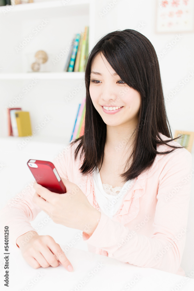 attractive asian woman using smart phone in the room attractive asian woman using smart phone in the room
