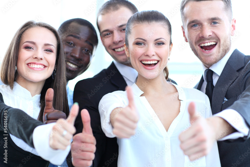 Successful young business people showing thumbs up sign Successful young business people showing thumbs up sign
