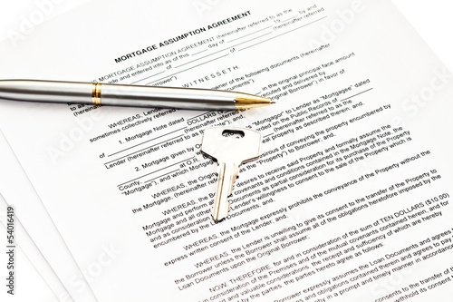 Mortgage assumption agreement with a pen for signature and a key