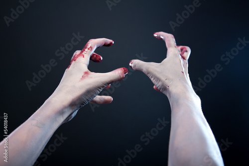 Grey skin bloody zombie hands photo