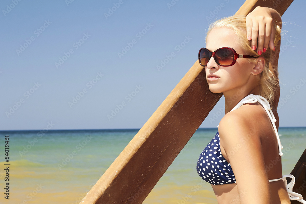 Beautiful blond woman on the beach. stairs to sea