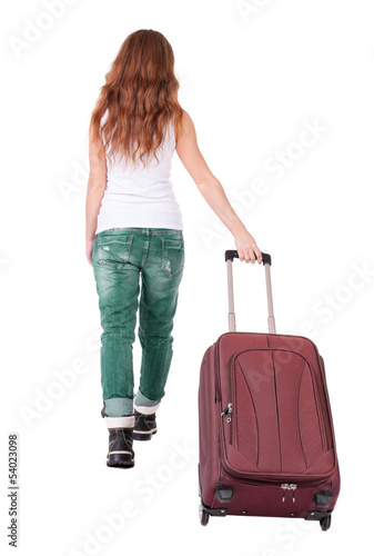 back view of walking woman with suitcase